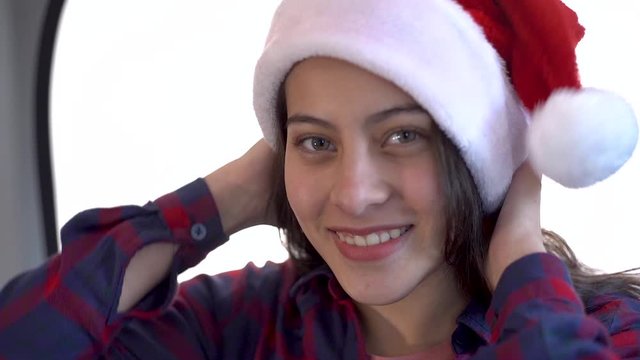 Beautiful girl put on a Christmas hat, she smiles and enjoys Christmas