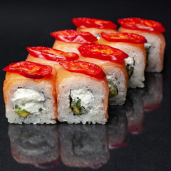 diverse delicious sushi roll set on a black background with reflection, menu