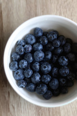 Bowl of fresh blueberries on a table. Top view.