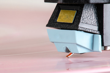 Close up of turntable cartridge on a vinyl record