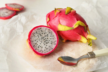 Board with tasty dragon fruit on table