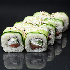 diverse delicious sushi roll set on a black background with reflection, menu