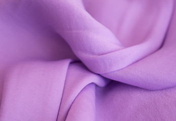 Purple soft fabric in light folds layout with sun highlights and shadows. Summer concept, femininity in trend, flatlay