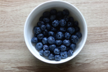 Bowl of fresh blueberries on a table. Top view.