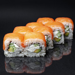 diverse delicious sushi roll set on a black background with reflection, menu
