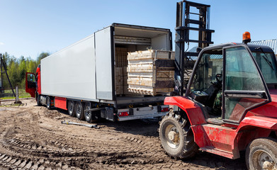 The machine loads the boards, lumber from the finished goods warehouse onto the truck
