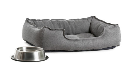 Comfortable pet bed and bowl with water on white background