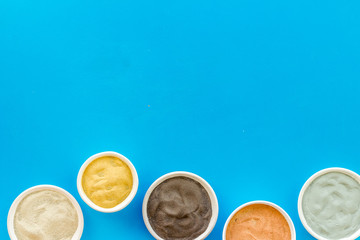 Yellow, red, white, blue and black cosmetic clay top view copy space