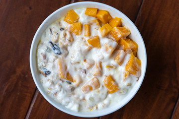 Granola with yellow mango and yogurt, close up