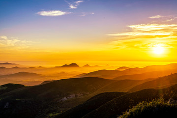 Obraz premium Sunset from View over Silhouetted Mountains 