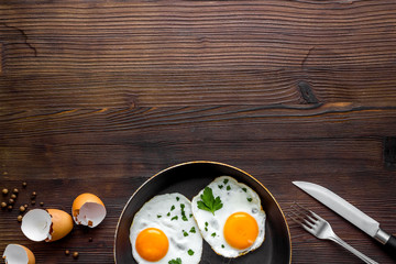 Fried egg on frying pan on wooden table top view copy space