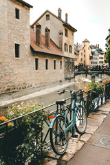 Fototapeta na wymiar Old bicycle parked near the Palais de l'Ile on the Annecy old town. The Palace, often described as a 