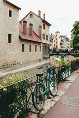 Old bicycle parked near the Palais de l'Ile on the Annecy old town. The Palace, often described as a 