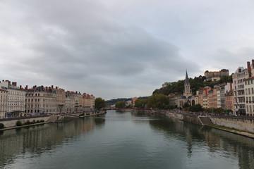 Obraz premium Heading into Vieux Lyon over the Pont Bonaparte. Quai Tilsitt and Quai Fulchiron on the banks of the Saone river, Passerelle, Saint Georges church and Saint-Just College on Fourviere hill, Lyon.