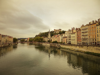 Obraz premium Heading into Vieux Lyon over the Pont Bonaparte. Quai Tilsitt and Quai Fulchiron on the banks of the Saone river, Passerelle, Saint Georges church and Saint-Just College on Fourviere hill, Lyon.