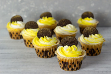 Delicious  cupcakes with yellow  cream and chocolate chip cookies.