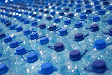 Lot of bottles worth with clean cool natural water. Group of plastic bottles with water stand in a row.