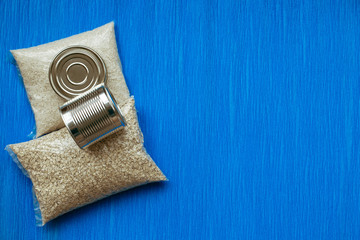 Rice, oatmeal, canned food, sugar. Food delivery, Donation, coronavirus quarantine. Food supplies crisis food stock for quarantine isolation period on blue background. Copyspace.