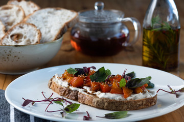 Breakfast table with natural fermentation toast with vegan curd, tomatoes and basil. Vegan food