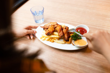 Woman having fried food on the wooden table.