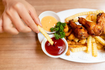 Woman having fried food on the wooden table.