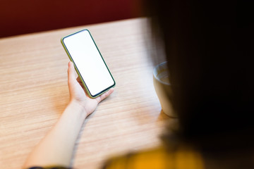 Woman using smart phone on the table in cafe.
