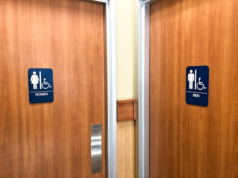 Two Public restroom doors with blue signs specifying male and female with handicap accessible features in both.