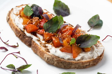 Breakfast table with natural fermentation toast with vegan curd, tomatoes and basil. Vegan food