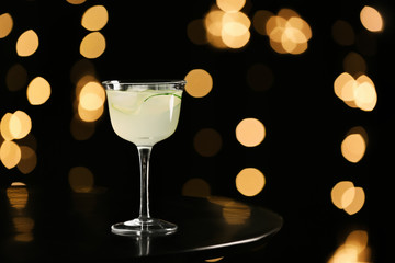 Glass of tasty cucumber martini on dark background