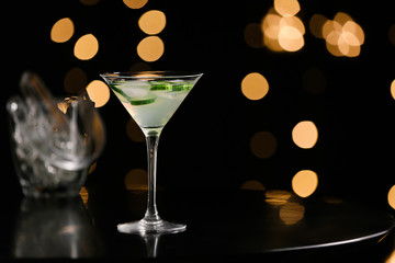Glass of tasty cucumber martini on dark background