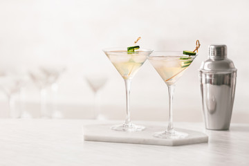 Glasses of tasty cucumber martini on table