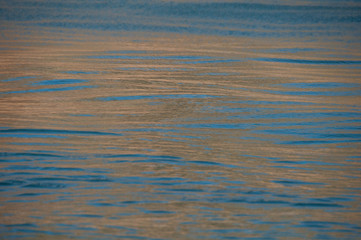 water texture. Horizontal orange lines created by the sunset reflection
