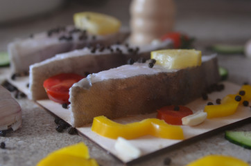 Close up halibut steaks raw and uncooked with peppers and pieces of vegetables. Healthy food and seafood