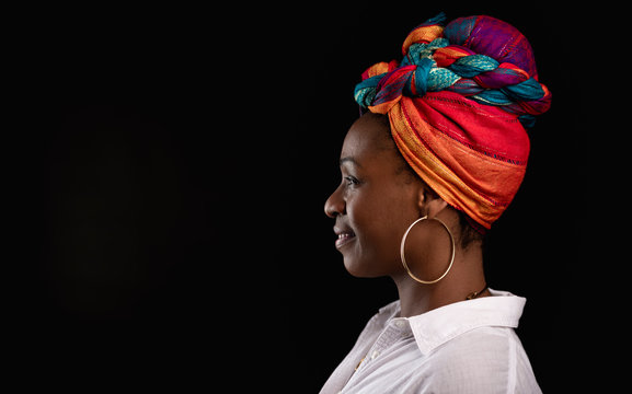 perfil de una impresionante morena con turbante de colores posando en un estudio