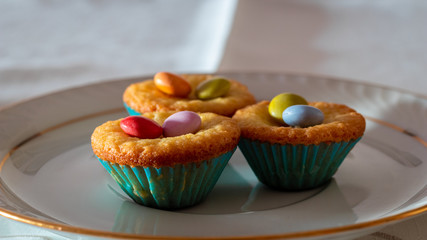Three cupcakes on a table with a elegant cup