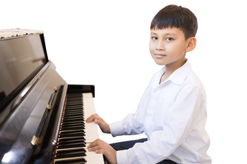 An Asian boy is practicing piano playing in a music classroom.
