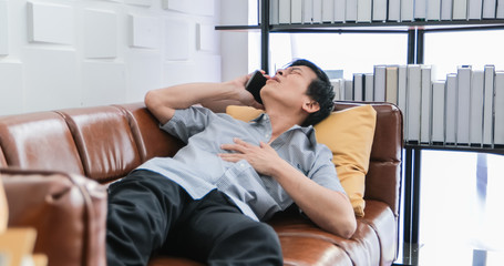 Fototapeta premium Old Asian people work hard until they become stressed and he feel bad on his heart and he call someone to help