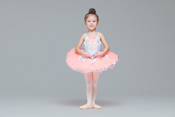 Leuk schattig ballerinameisje in roze tutu-danspraktijken balletdansen