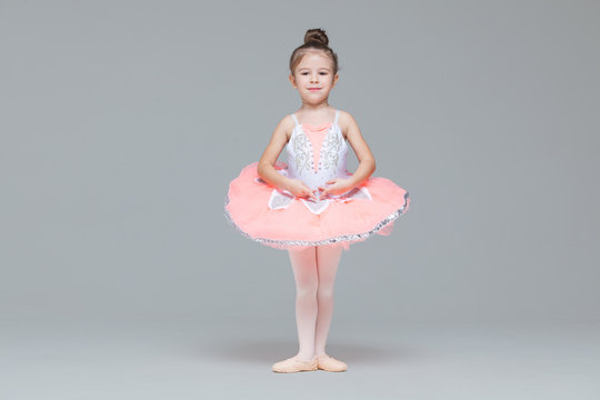 Cute adorable ballerina little girl in pink tutu dance practices ballet dancing