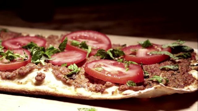 Turkish pizza lahmacun with black background.