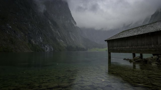 A 4k time lapse with the boat shed and mist rising above the mountains at Obersee in Germany