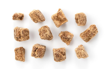 Take a bird's-eye view of brown sugar chunks on a white background