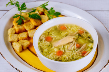Noodle soup with chicken, parsley and croutons.