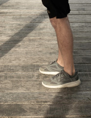 Person male man in sneakers and shorts and hoodie looking out over the ocean sea on a jetty at Semaphore in Adelaide South Australia at late afternoon sunset