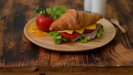 Close up view of breakfast meal with  croissant sandwich ham and cheese