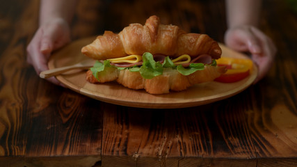 Close up view of Pastry Chef serving fresh croissant sandwich ham and cheese