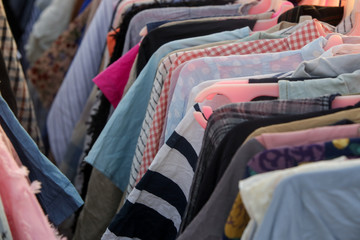Huge selection of different used clothes for men, women and children on the rack in a second hand...