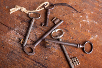 Five vintage keys arranged on a distressed wooden tabletop