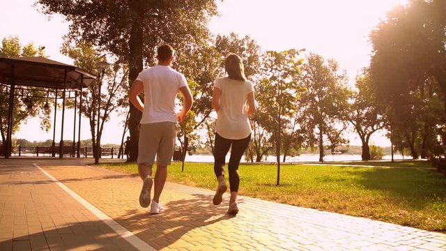 motivation for healthy lifestyle people jumping for giving high five celebrating success after workout slow motion lens flare summer landscape