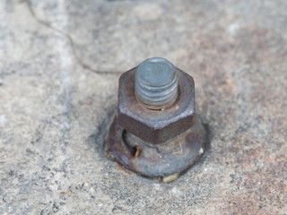 Old and rusty steel hex bolt and nut on the concrete wall. Attached metal screw in the cement. Corrosion from weathered and oxidation. 